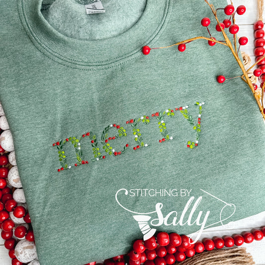 Green sweatshirt with "merry" embroidered in festive leaves and berries font, perfect for adding a touch of cheer to your wardrobe. Stitching by Sally 