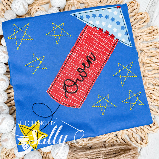 A cute firecracker is appliquéd in red and blue fabric on a royal blue shirt. A name is added with embroidery. 