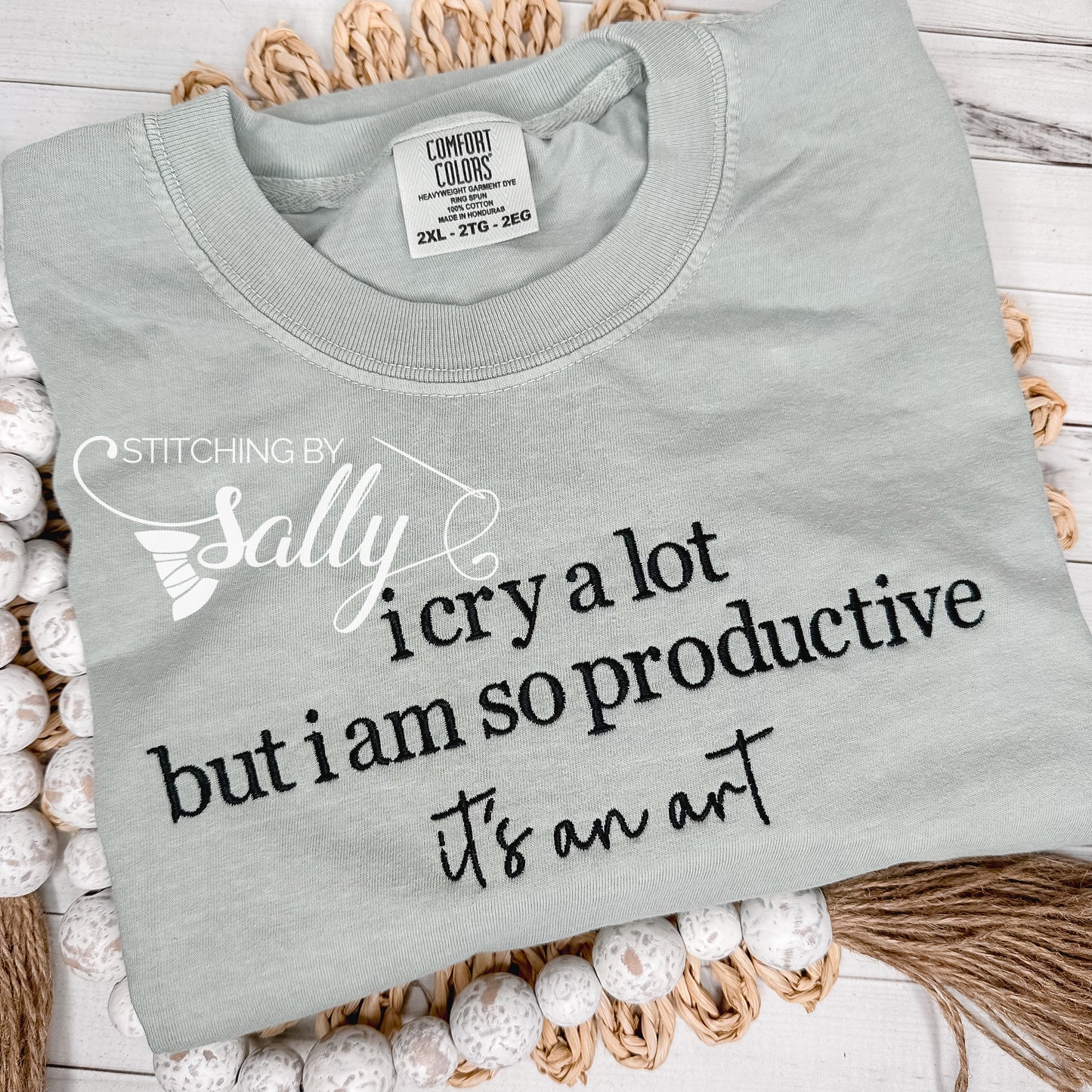 A green T-shirt with the text "I cry a lot but I am so productive it's an art" embroidered in black. Stitching by Sally