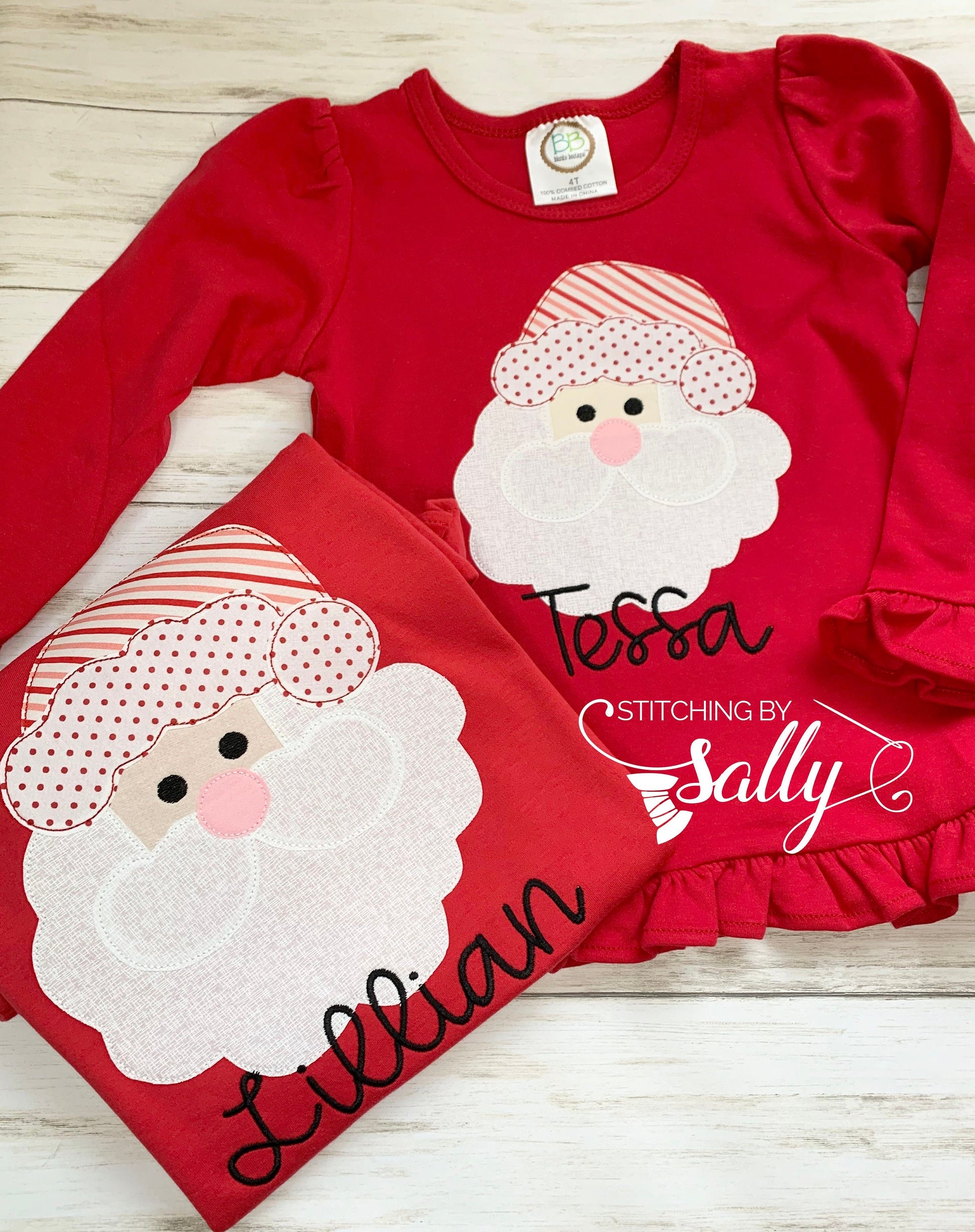 Matching red girl shirts with a santa face applique in red and white fabric. Personalized with name in black thread. 